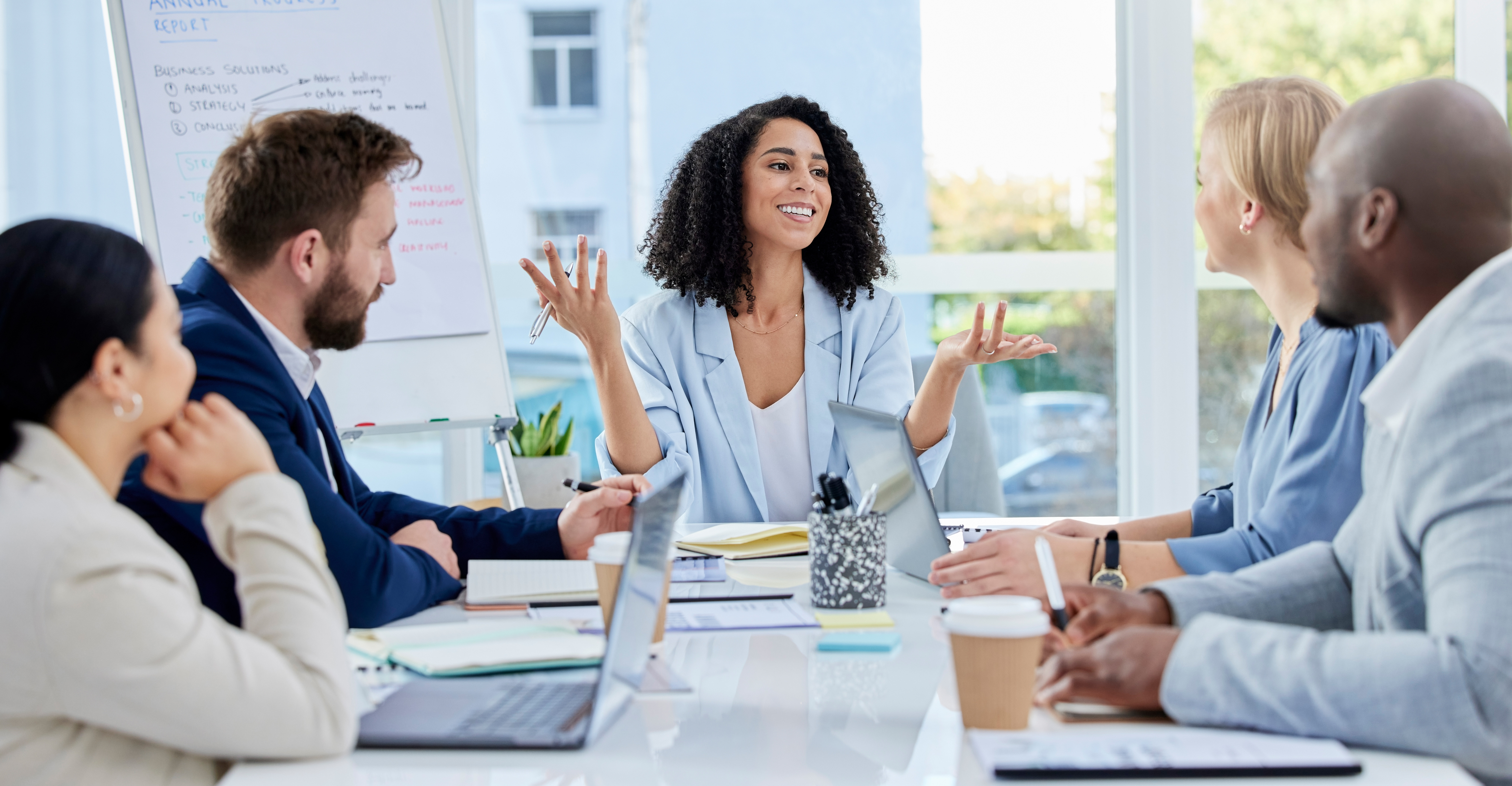 Black woman, leadership and business people in meeting, strategy or sharing planning idea at office. Happy African American female leader discussing project plan in teamwork collaboration at workshop